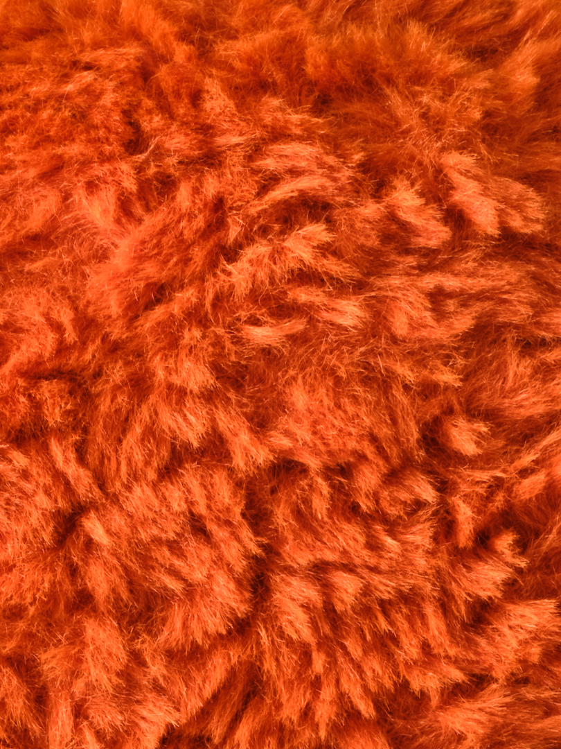 Close-up texture of soft, Red-Orange "fried" plush fabric used for stuffed animals, fuzzy toys, or Spicy Chicken Nuggets showcasing fluffy and cozy material perfect for cuddly products