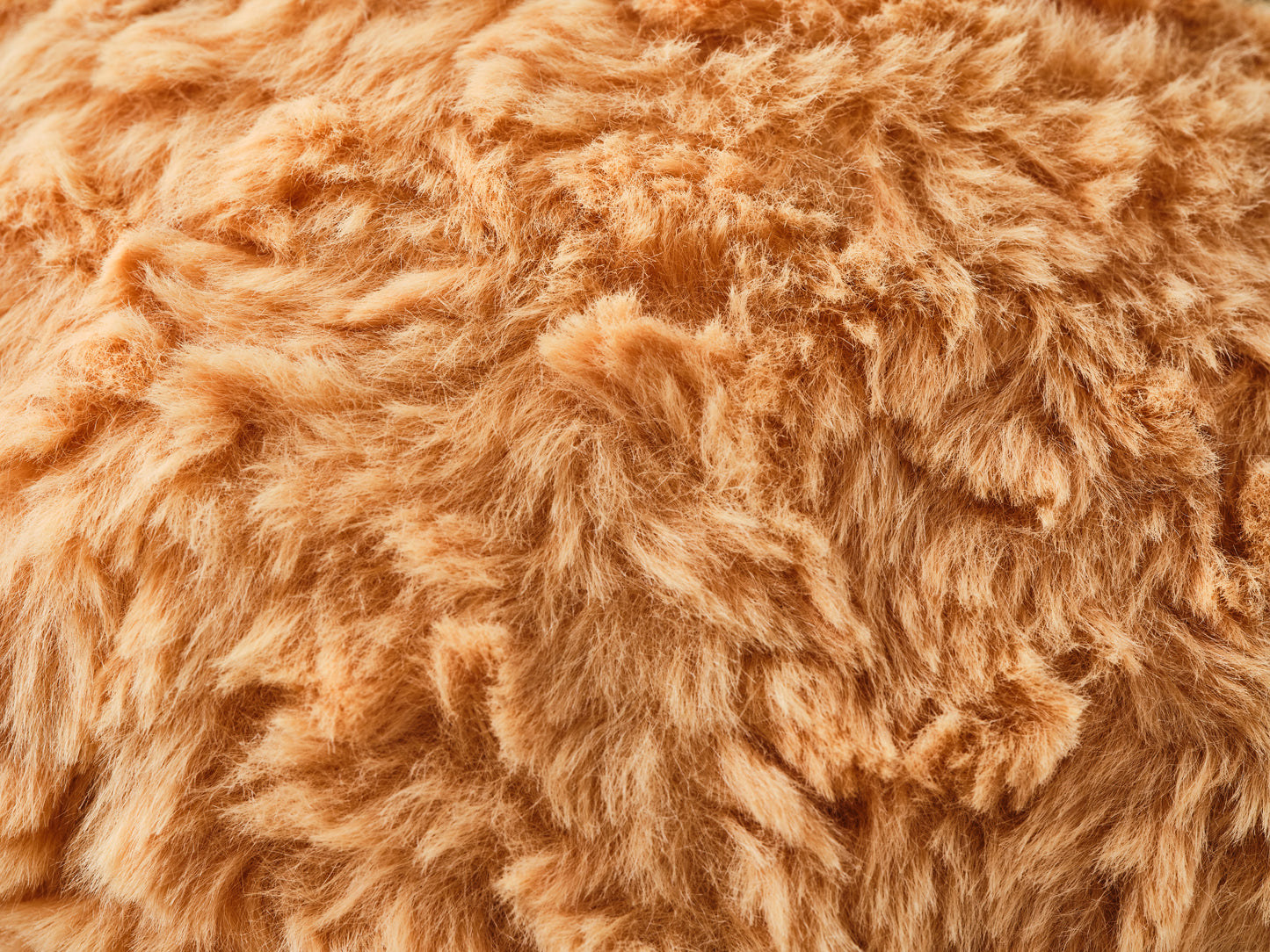 Close-up texture of soft, yellow-orange "fried" plush fabric used for stuffed animals or fuzzy toys, showcasing fluffy and cozy material perfect for cuddly products