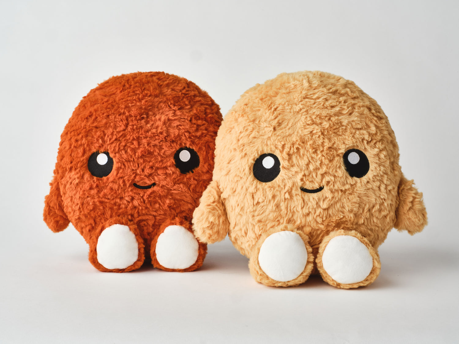 Spicy and original chicken nugget plush toys side by side, featuring round cuddly shapes, fluffy textured fabric in orange and golden brown, cute embroidered faces, and soft white feet — ideal for gifting, collecting, or comfort cuddles