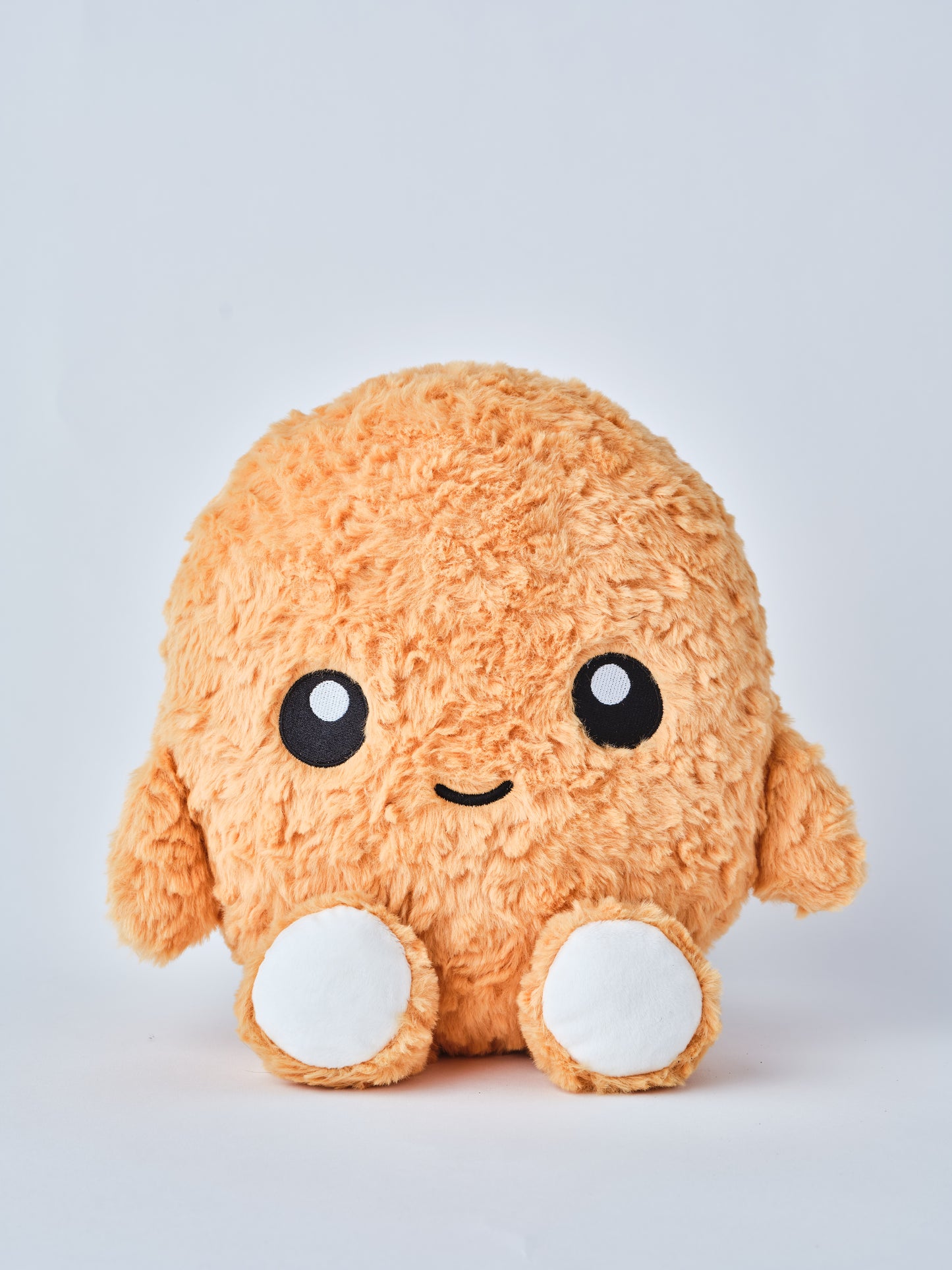 Cute plush chicken nugget toy with a smiling face, round white feet, and fuzzy orange texture, sitting on a white background — perfect for kids or novelty gift lovers.
